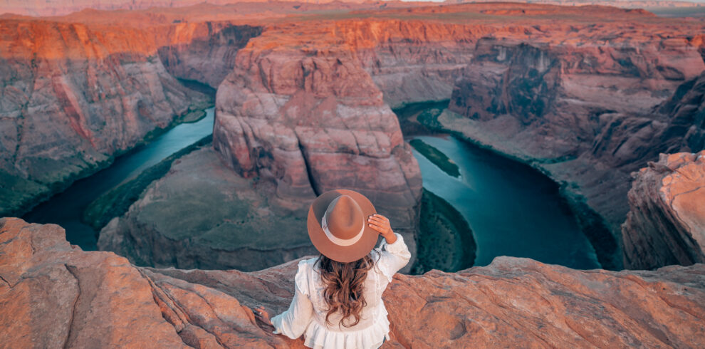 a traverler sitting the side of Horseshoe Bend